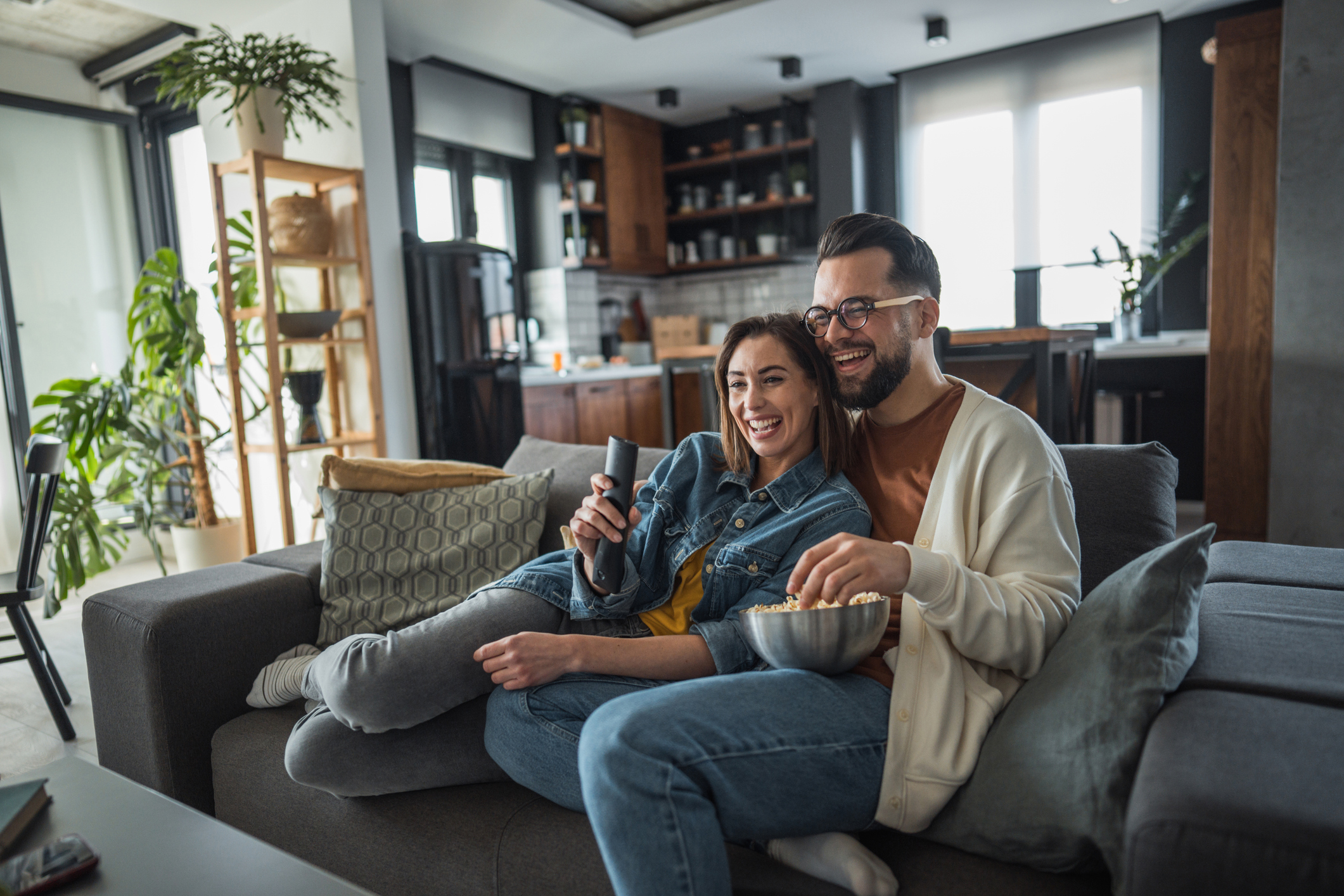 Young couple resting at home, spending a relaxed weekend day together watching TV