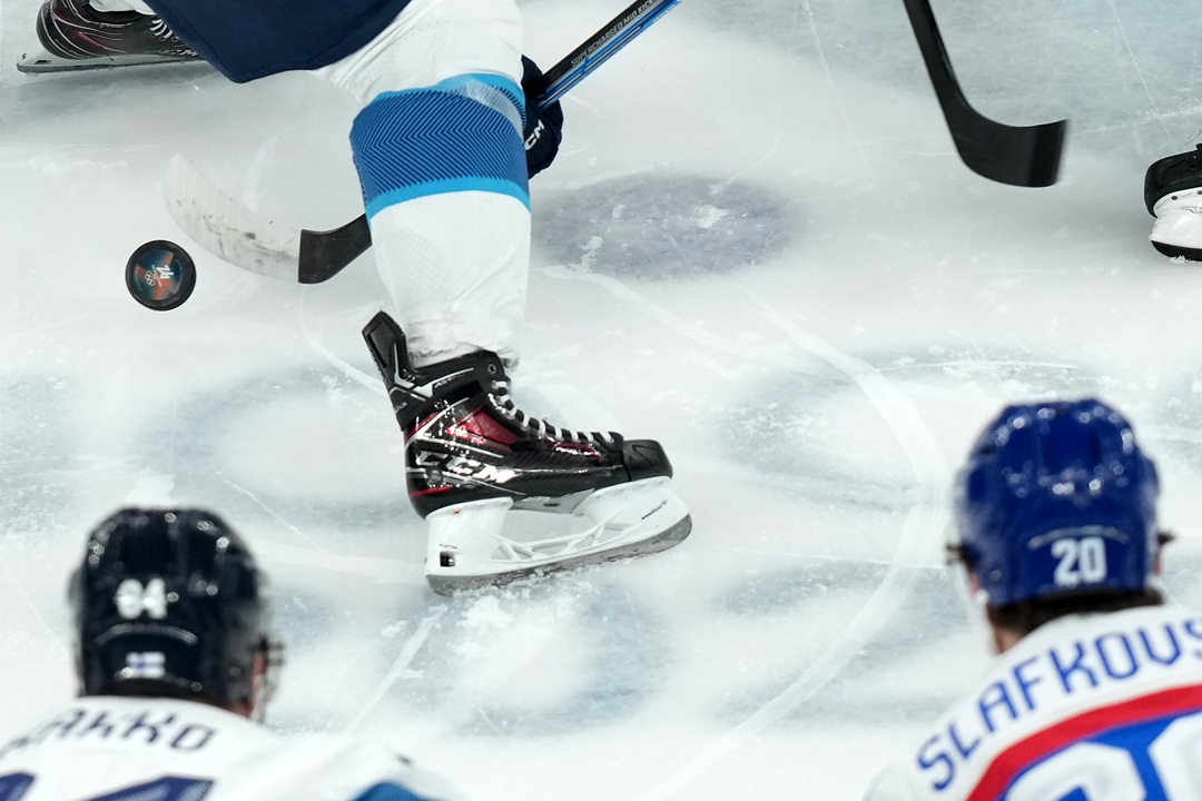 Finland's Kaapo Kakko (84) and Slovakia's Juraj Slafkovsky (20) watch as players battle for the puck during the opening face-off to start the first period of the men's ice hockey bronze medal game at the 2026 Winter Olympics in Milan, Italy, Saturday, Feb. 21, 2026. (AP Photo/Carolyn Kaster)