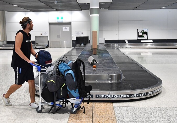 A man is seen walking past an empty baggage carousel at the Brisbane domestic airport terminal in Brisbane, Monday, March 23, 2020. The Queensland Government has announced that they will close the state's borders to stop the spread of the Coronavirus (COVID-19) outbreak, beginning at midnight on Wednesday and they will force anyone entering Queensland to quarantine themselves for 14 days after their arrival. (AAP Image/Darren England) NO ARCHIVING