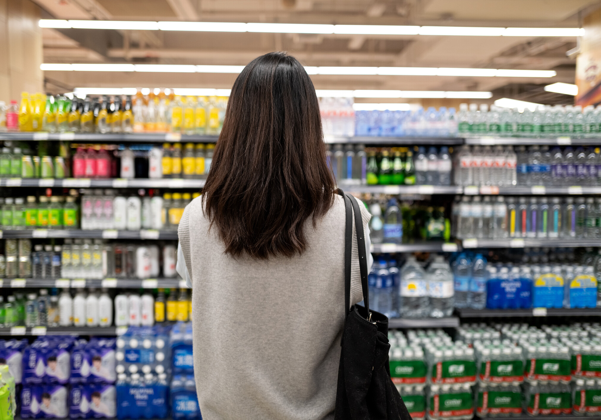Back view of female millennial customers in supermarket
